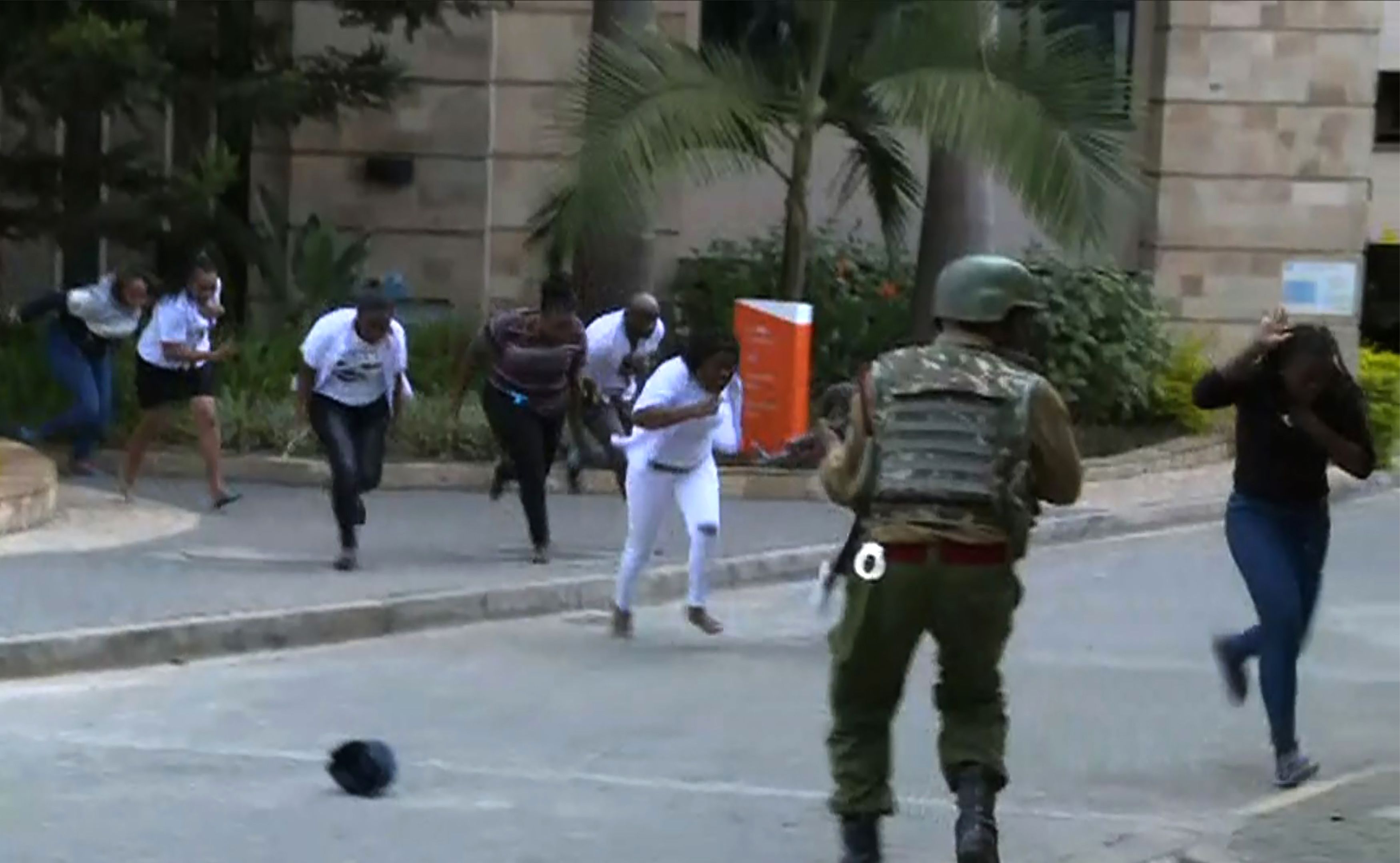 Image taken from an AFP TV footage shows people running in a street as a gunfight was underway following a blast at a hotel and office complex in a leafy Nairobi neighbourhood on January 15, 2019.