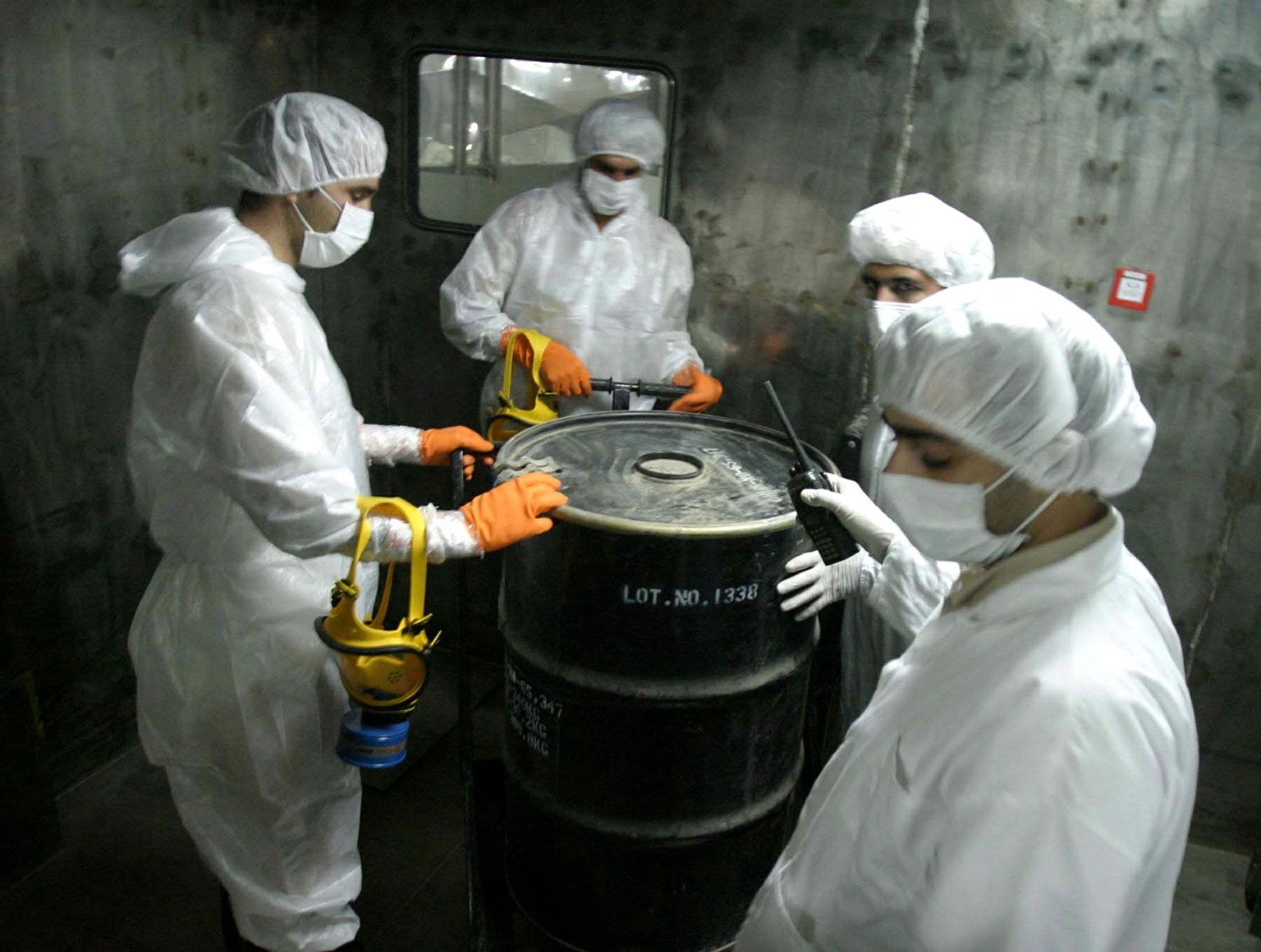 Iranian technicians lift a barrel of "yellow cake" to feed it into the processing line of Uranium Conversion Facility (UCF) in Isfahan, Iran in an August 8, 2005 file photo.