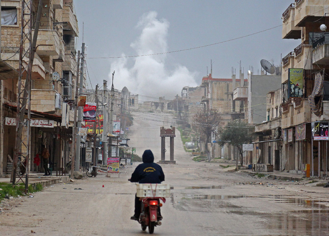 A man rides a scooter on a street during reported air strikes in the town of Khan Sheikhun in the southern countryside of the rebel-held Idlib province, on February 22, 2019.