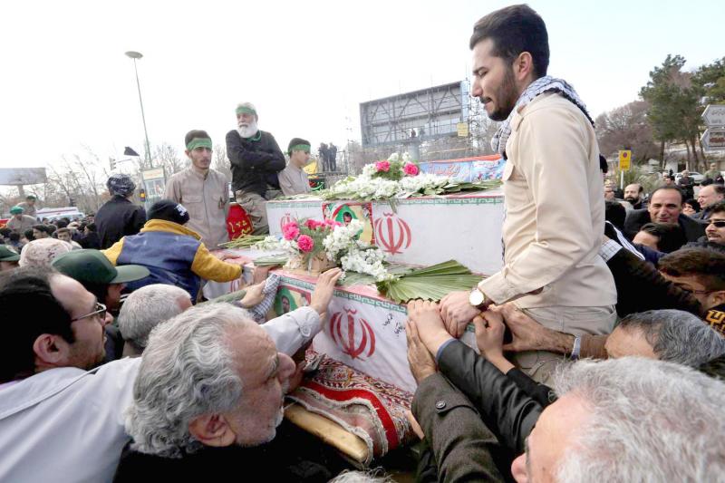 Iranian mourners gather around the coffins of members of Islamic Revolutionary Guard Corps who were killed February 13 in a suicide attack, during their funeral in Isfahan, February 16