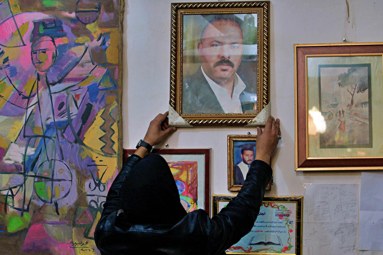 ابن علاء مشذوب يعلق صورة أبيه في بيته