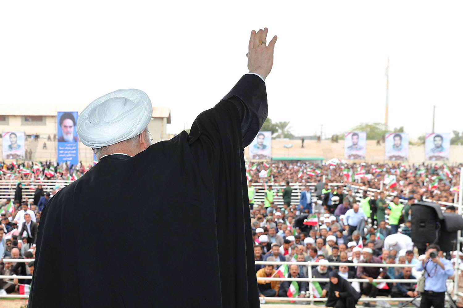 الرئيس الإيراني حسن روحاني يلوح لحشد يحتفل بذكرى الثورة الإيرانية