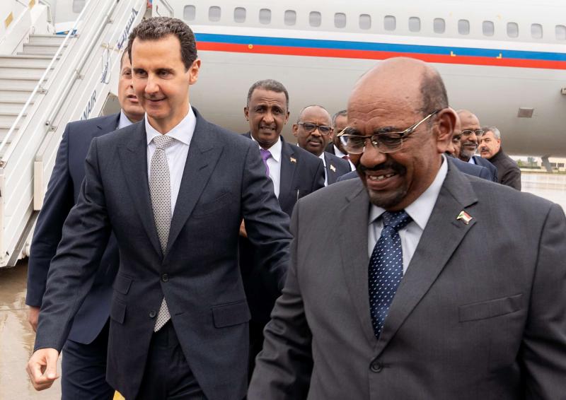 Breaking isolation? Syrian President Bashar Assad (L) receiving Sudanese President Omar al-Bashir at Damascus Airport, December 16