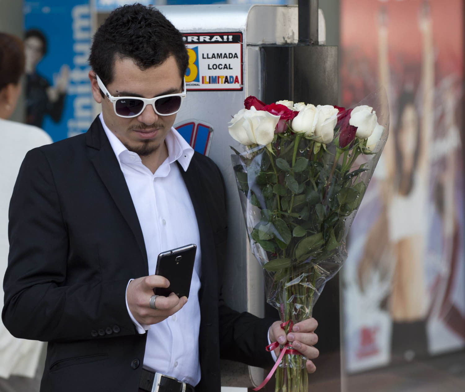 مكسيكي يحمل باقة زهور ويدقق هاتفه في يوم الحب