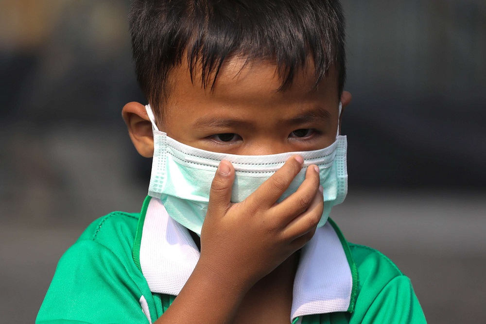 طفل في بانكوك يضع كمامة أثناء ذهابه للمدرسة اتقاء من الهواء الملوث