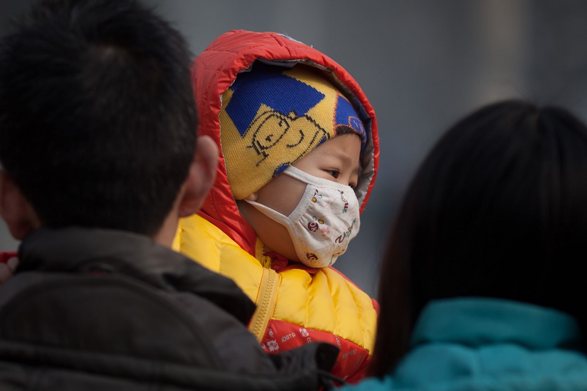 طفل صيني يضع كمامة للحماية من الهواء الملوث