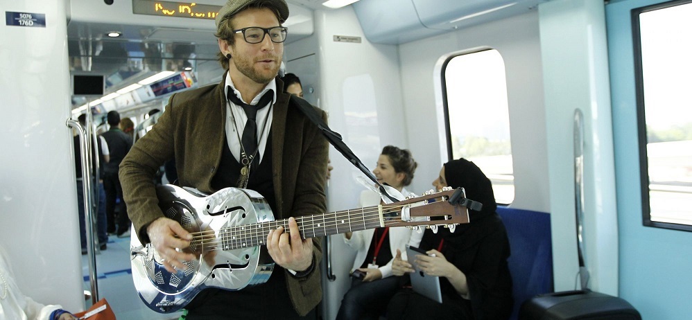 فنان يعزف على الغيتار داخل إحدى مقصورات مترو دبي في العالم 2013