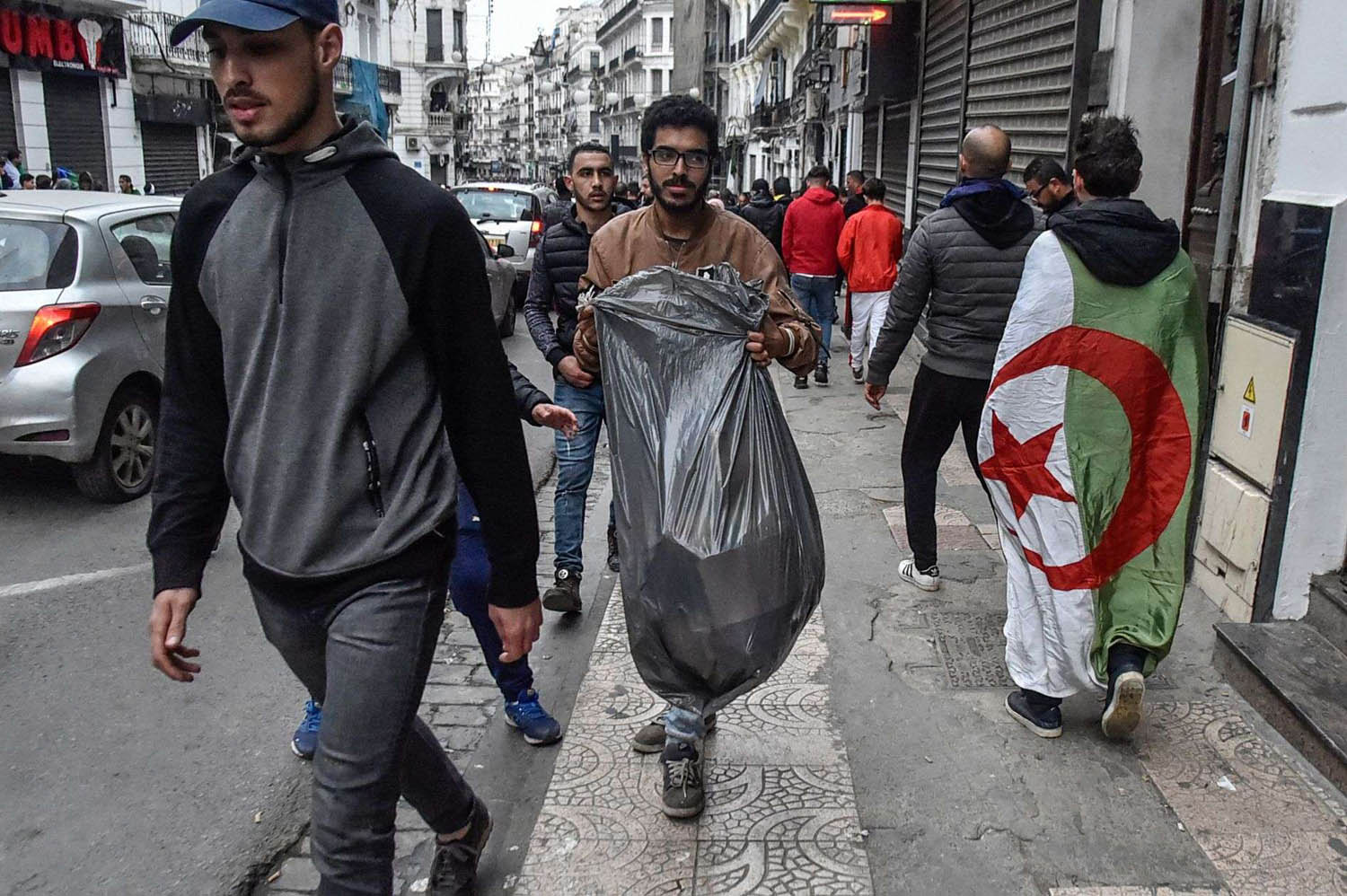 شباب متطوعون يرفعون القمامة المتخلفة بعد الاحتجاجات في الشوارع في الجزائر
