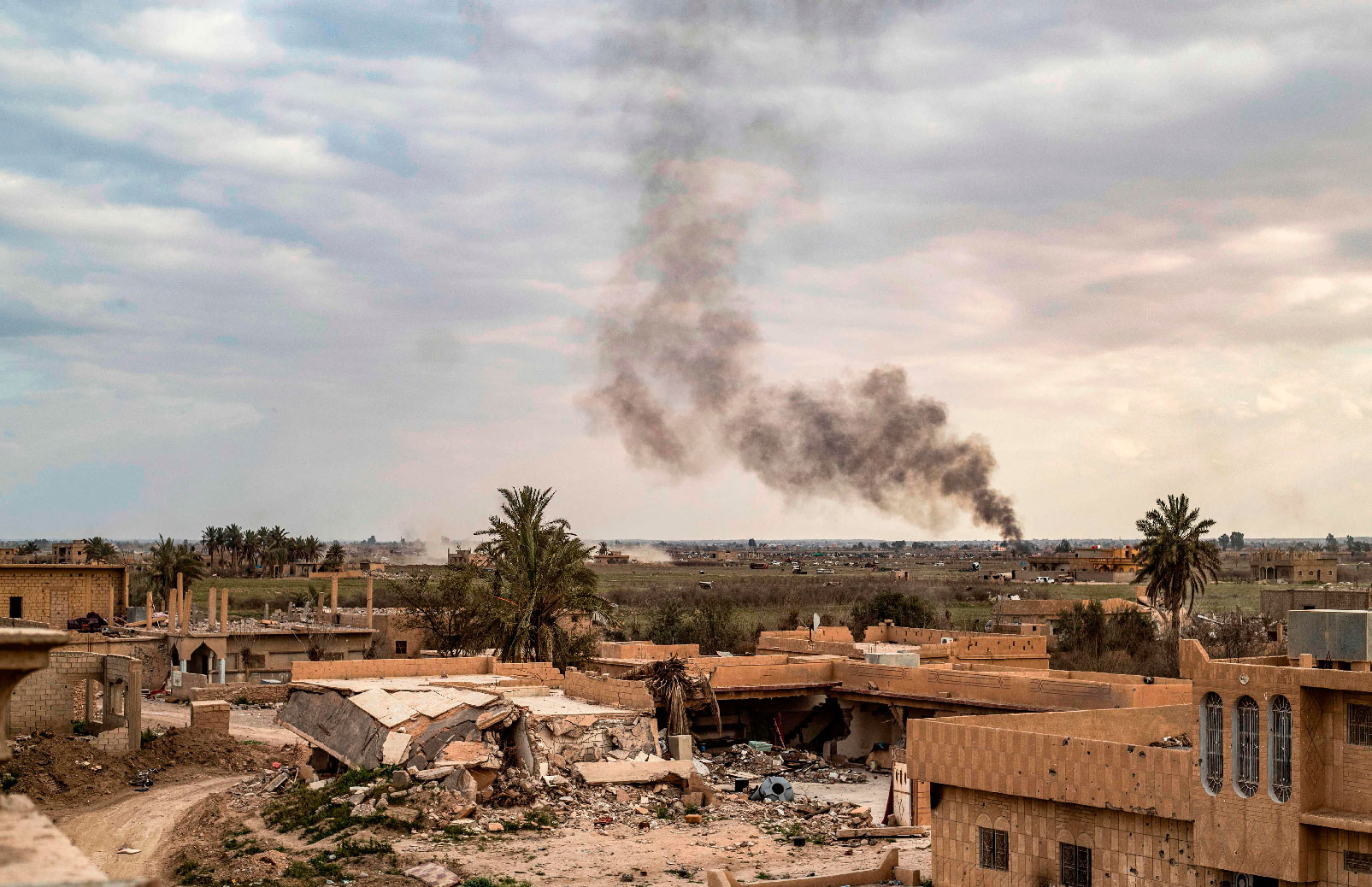 Smoke plumes billow from the remains of an Islamic State (IS) group jihadists' camp near the village of Baghouz in the eastern Syrian province of Deir Ezzor, on March 15, 2019.