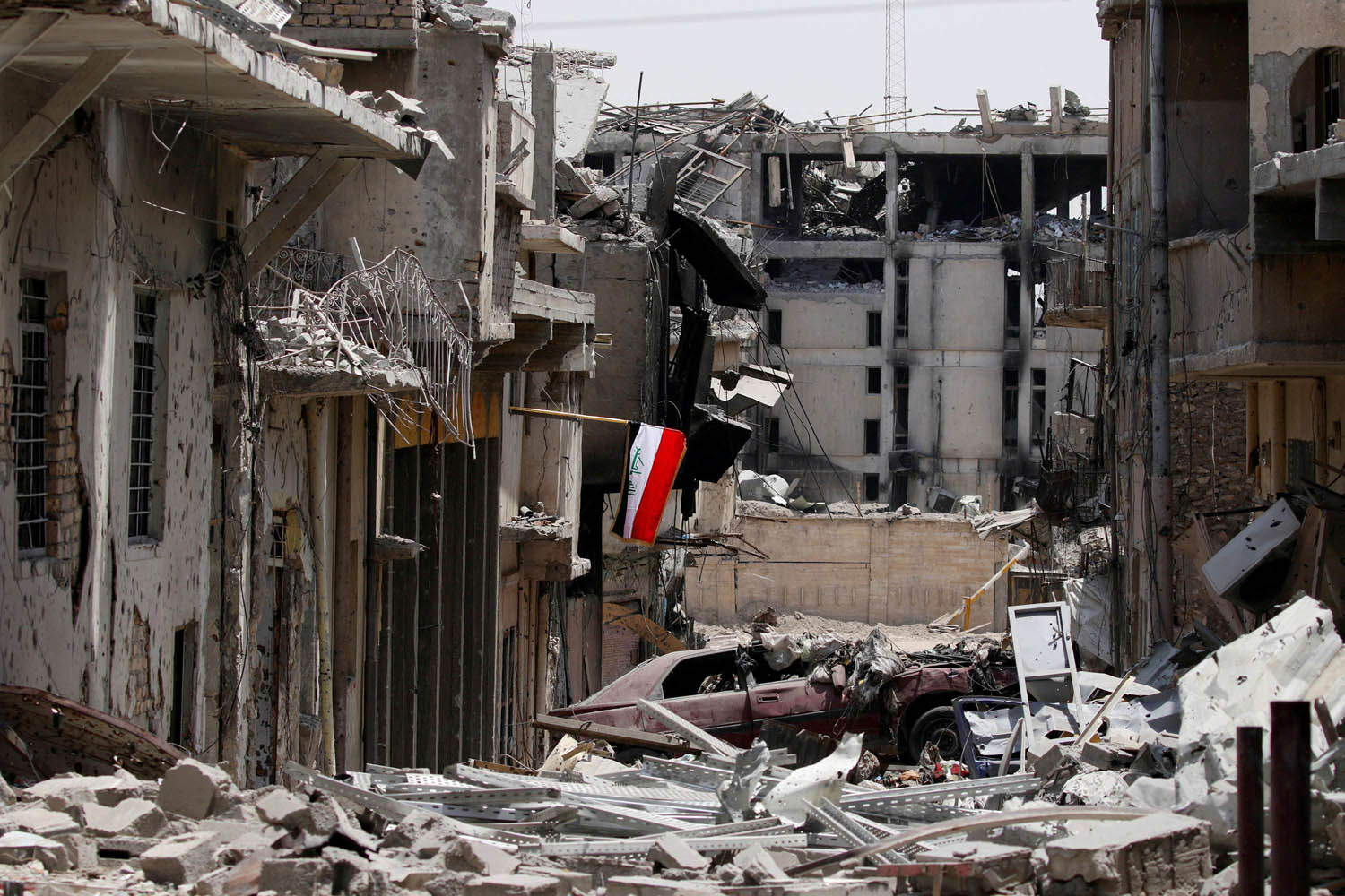 علم عراقي وسط حطام المباني في مدينة الموصل