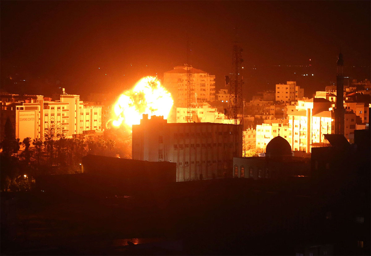 A ball of fire billows above buildings in Gaza City during Israeli strikes 