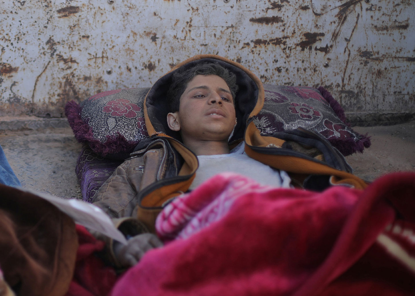 Hareth Najem, an Iraqi orphan lies under a blanket in a truck, near the village of Baghouz, Deir Al Zor province, Syria March 1, 2019. Picture taken March 1, 2019.