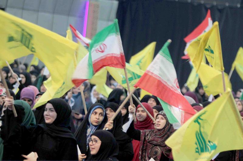 Two sides of the same coin. Hezbollah supporters wave flags of Iran and their Shia group during a rally to mark the anniversary of the Iranian Islamic Revolution, February 6