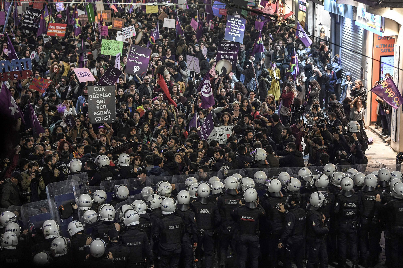 Turkish anti-riot police officers push back women during a rally marking International Women's Day on Istiklal avenue in Istanbul on March 8, 2019. 