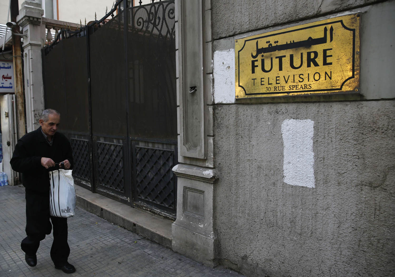 لبناني يمر بجانب بناية مؤسسة المستقبل الاعلامية