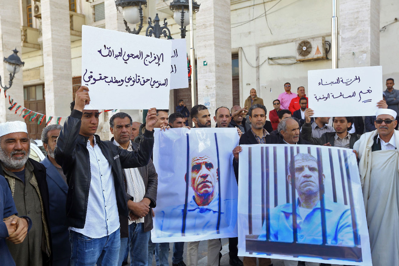 Family and tribe members of imprisoned former Libyan intelligence chief Abdullah al-Sanussi, demonstrate with signs calling for his release and showing his picture on posters, in the Libyan capital Tripoli on March 23, 2019.