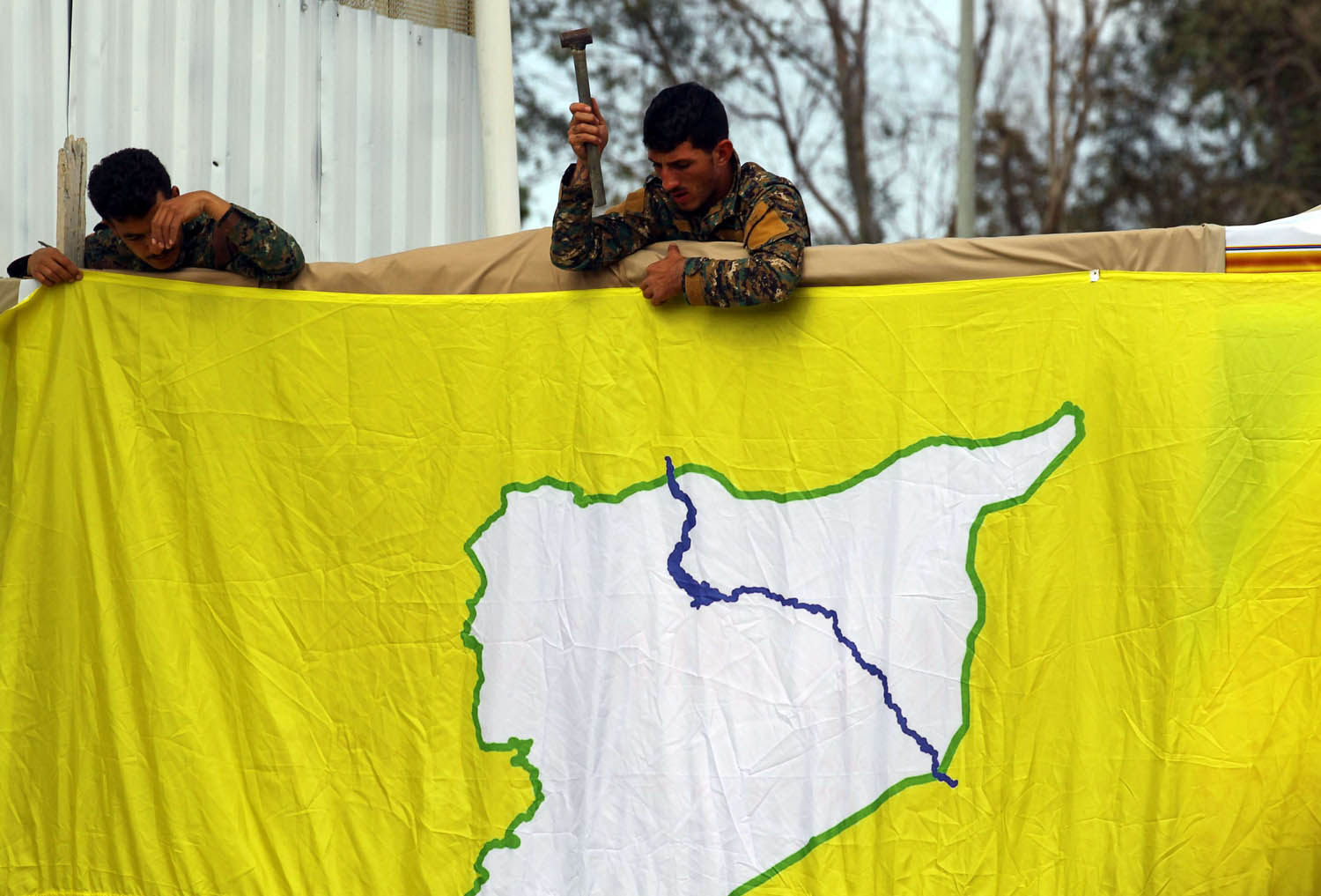 أكراد سوريون يثبتون علم "قوات سوريا الديمقراطية" على مدخل حقل نفطي قرب دير الزور