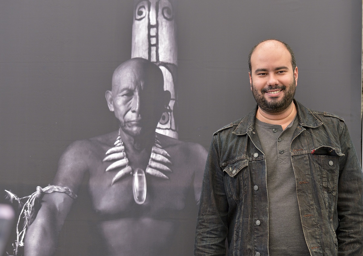 المخرج الكولومبي سيرو غيرا رئيس لجنة تحكيم أفلام أسبوع النقاد يقف بجانب صورة لفيلمه "احتضان الثعبان"