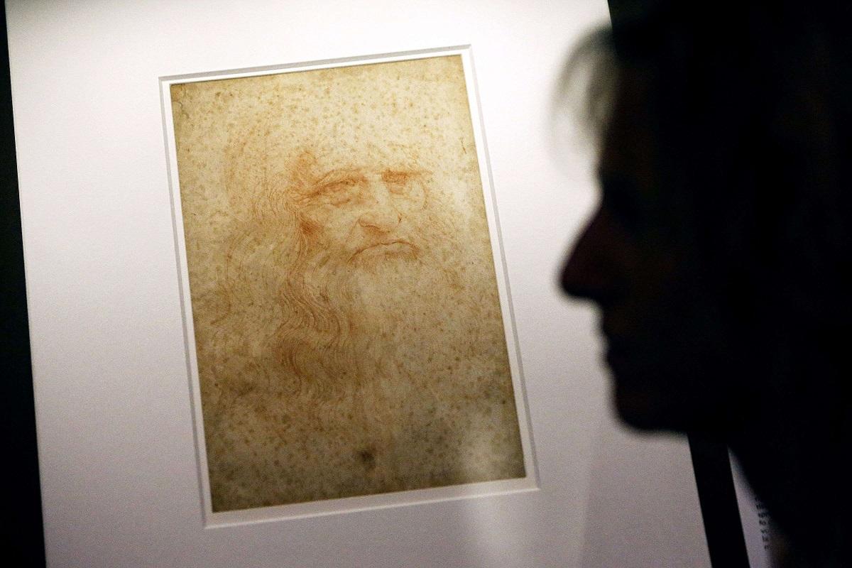زائر يقف بجانب الصورة الذاتية لليوناردو دافنشي في معرض "عالم ليوناردو" بتورينو/ايطاليا