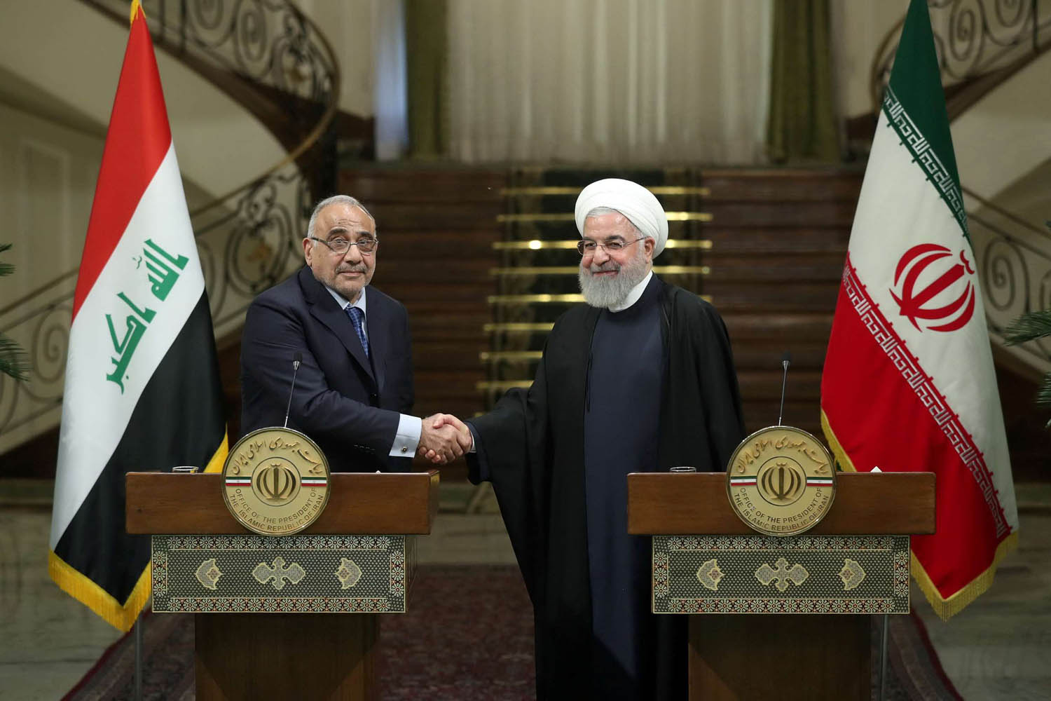 الرئيس الإيراني حسن روحاني يصافح رئيس الوزراء العراقي عادل عبدالمهدي خلال زيارته لطهران