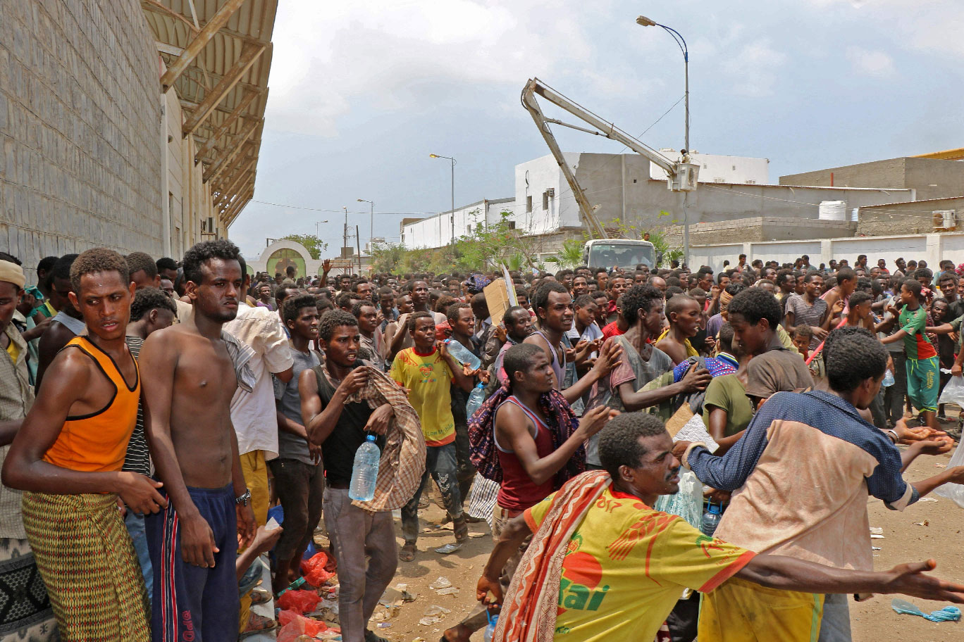 African migrants receive food and water inside a football stadium in the Red Sea port city of Aden