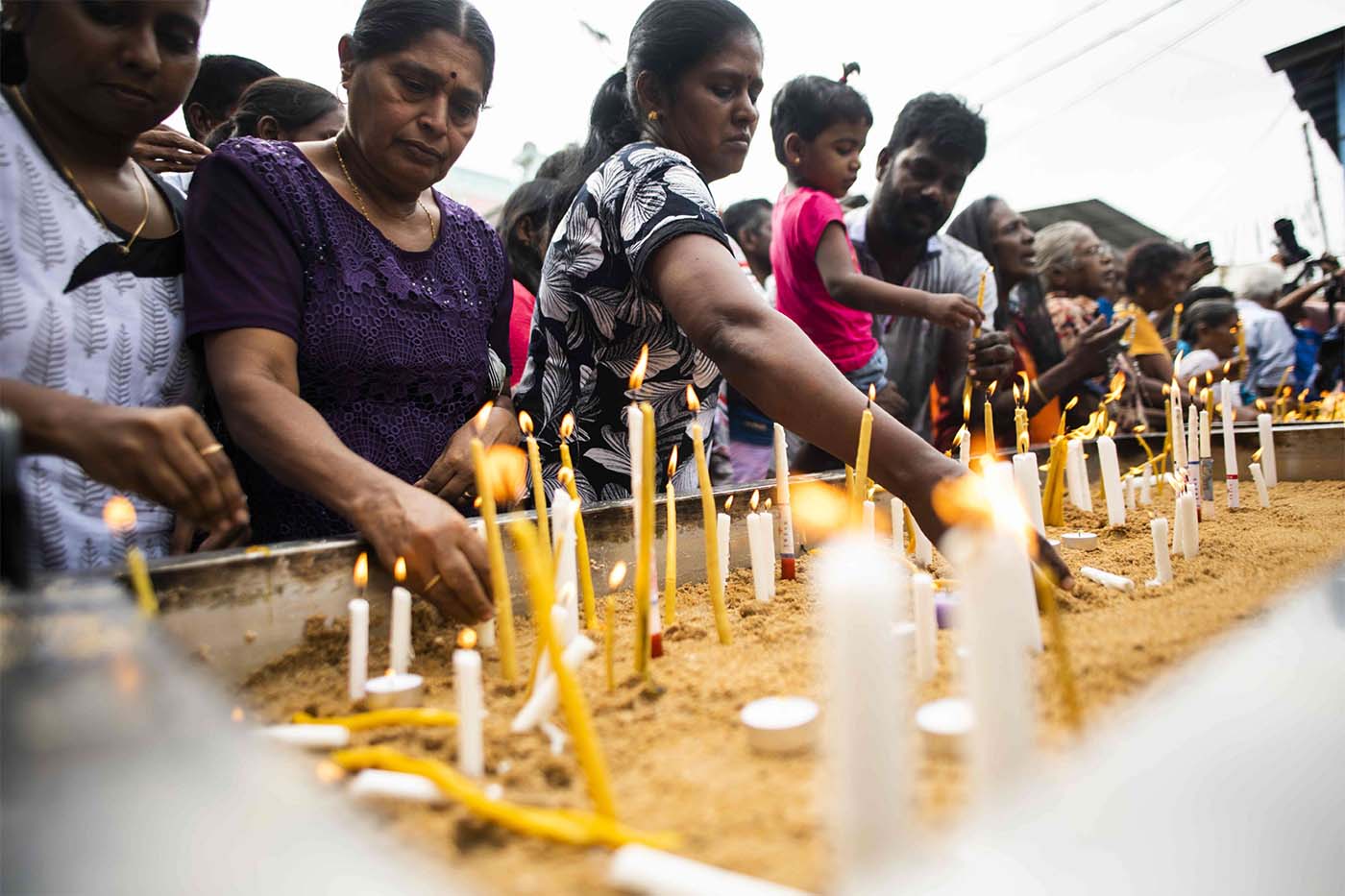 Sri Lankan Christian devotees light candles as they pray for victims of horrific Easter bombings