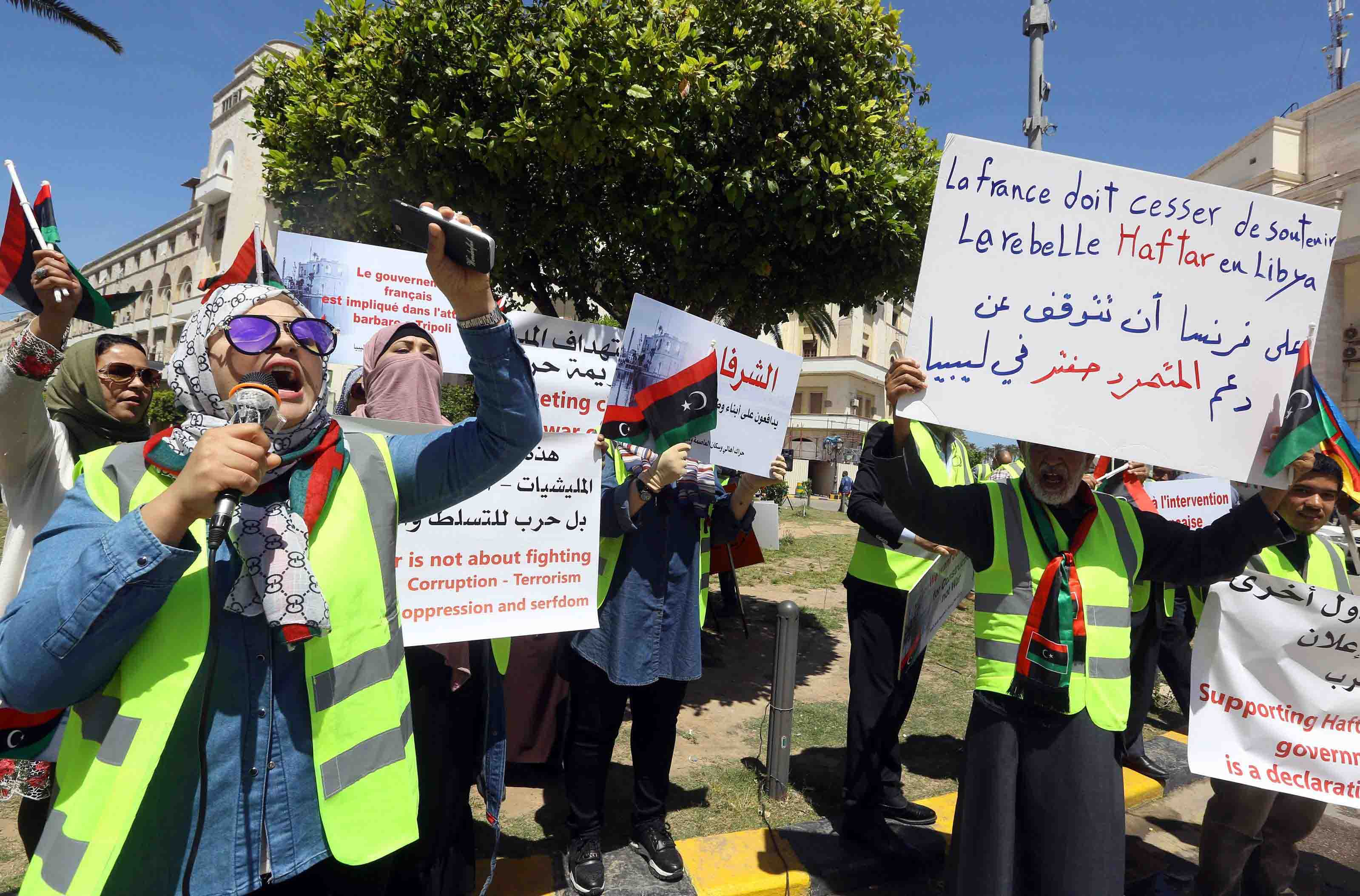 Libyan demonstrators hold signs against what they call foreign intervention in Libya