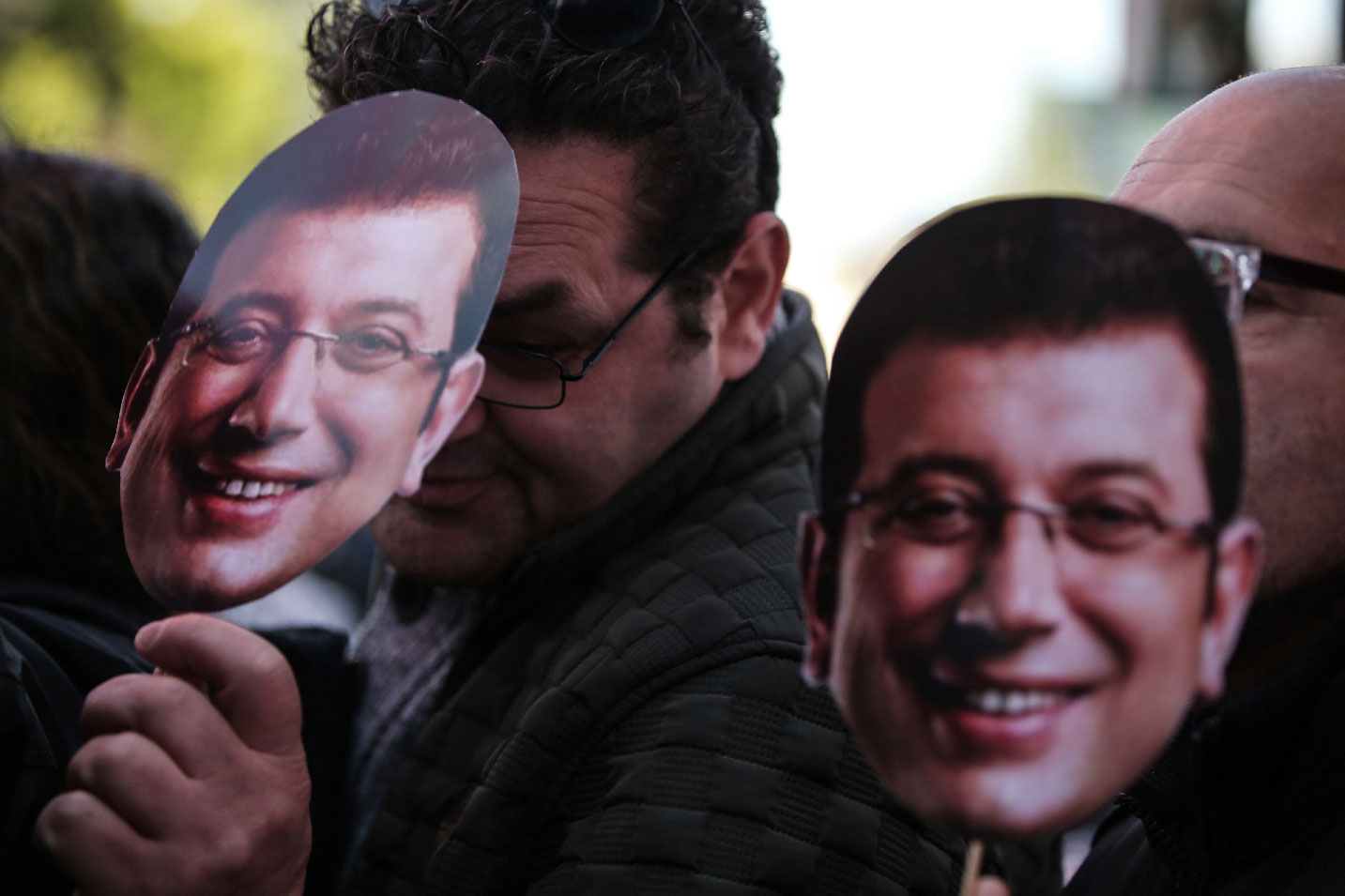 People wear the masks of Ekrem Imamoglu, the main opposition mayoral candidate for Istanbul