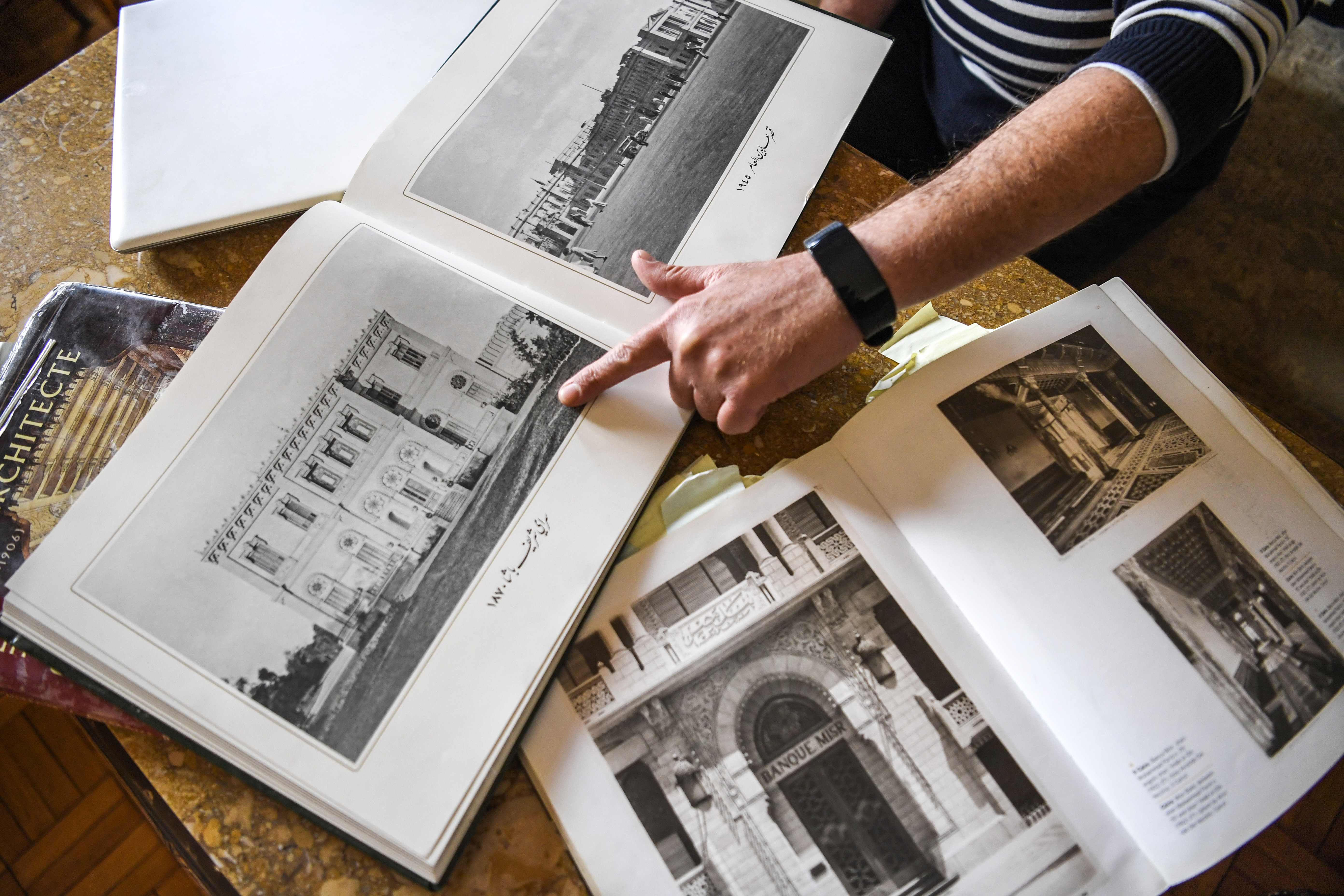 Ahmed al-Bindari, an Egyptian historian and photographer of modern (19th-20th century) Cairene architecture, points at an architecture catalogue showing the historic Sherif Pasha Serail (dating to 1870), during an interview at his office in the capital Cairo on March 8, 2019.
