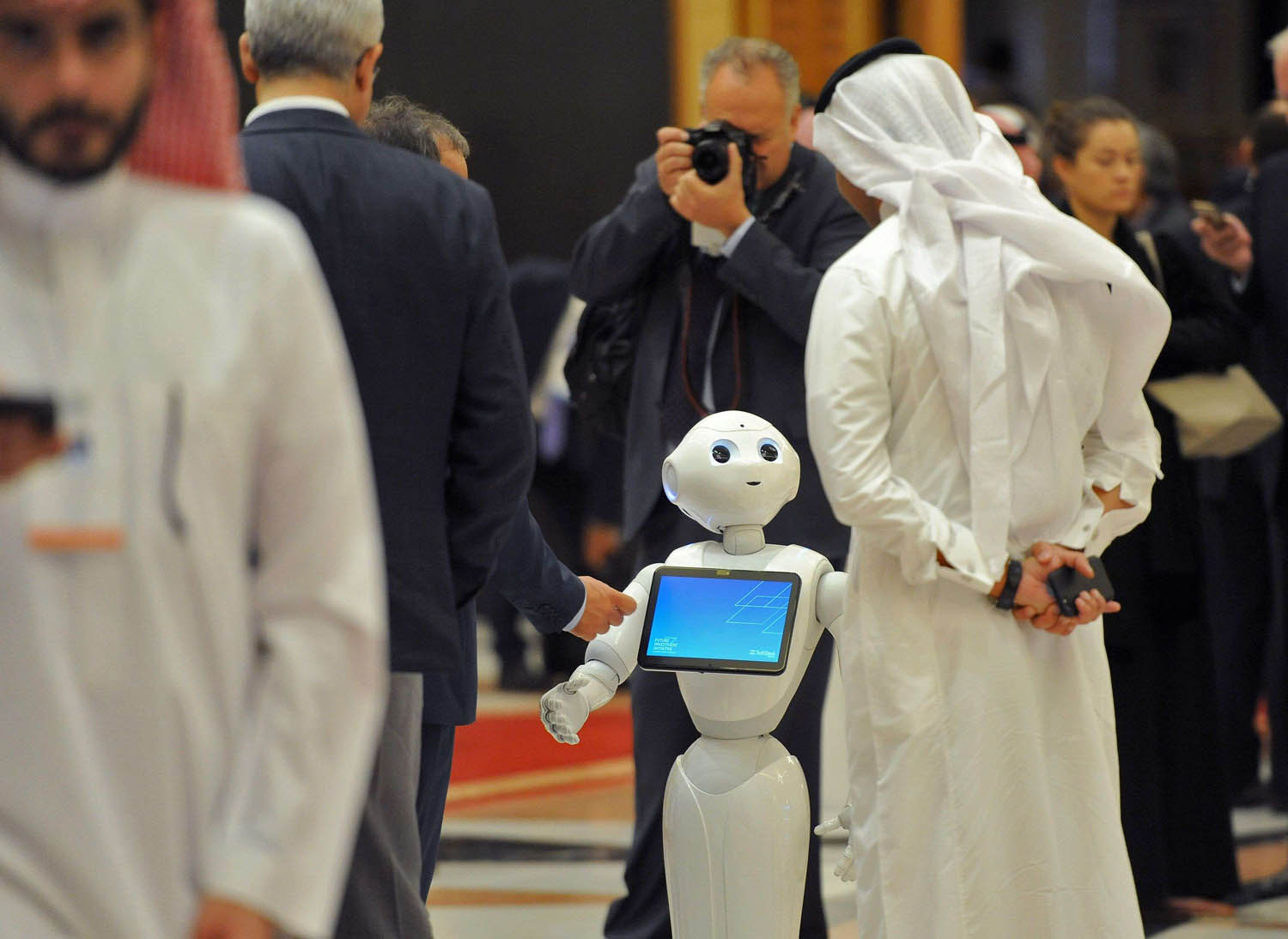سعودي ينظر إلى روبوت في مؤتمر بالرياض
