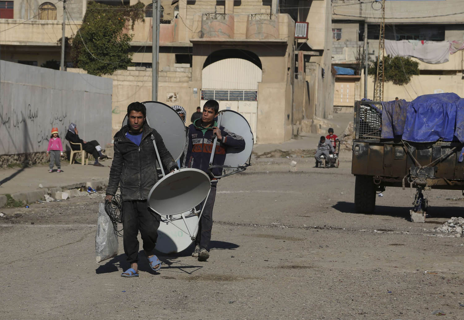 عراقيون يحملون صحونا لاقطة في الموصل