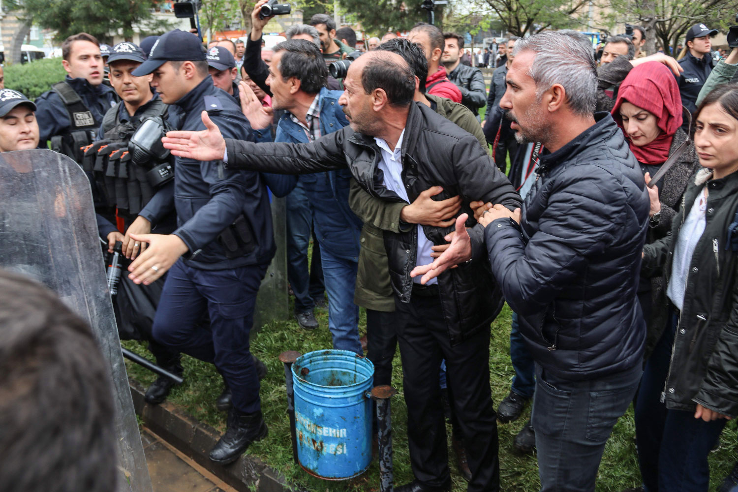 Pro-Kurdish Peoples's Democratic Party (HDP) members discuss with Turkish police during a protest against results of the local elections