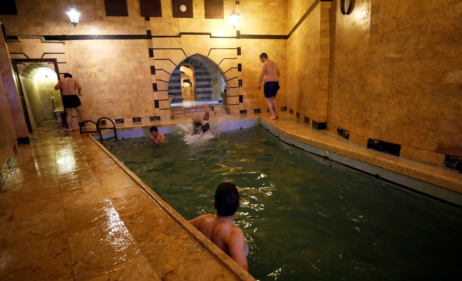 Men swim in a pool in Aleppo's Bab al-Ahmar public bathhouse