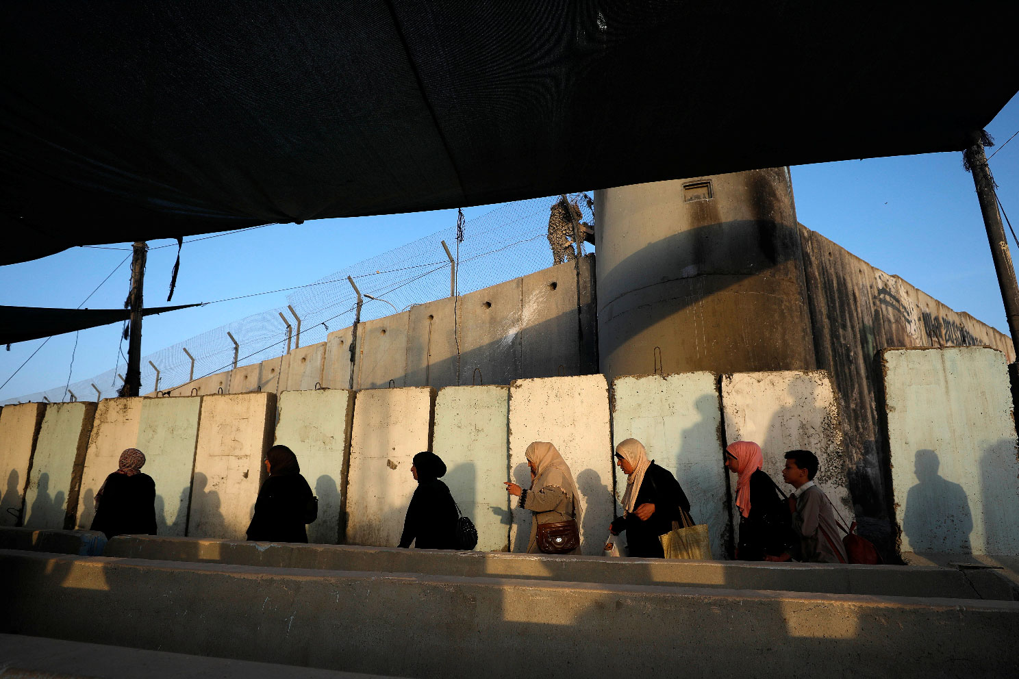 Palestinians make their way along Israel's apartheid wall to attend Friday prayer in Jerusalem's al-Aqsa mosque, at Qalandia checkpoint in the occupied West Bank