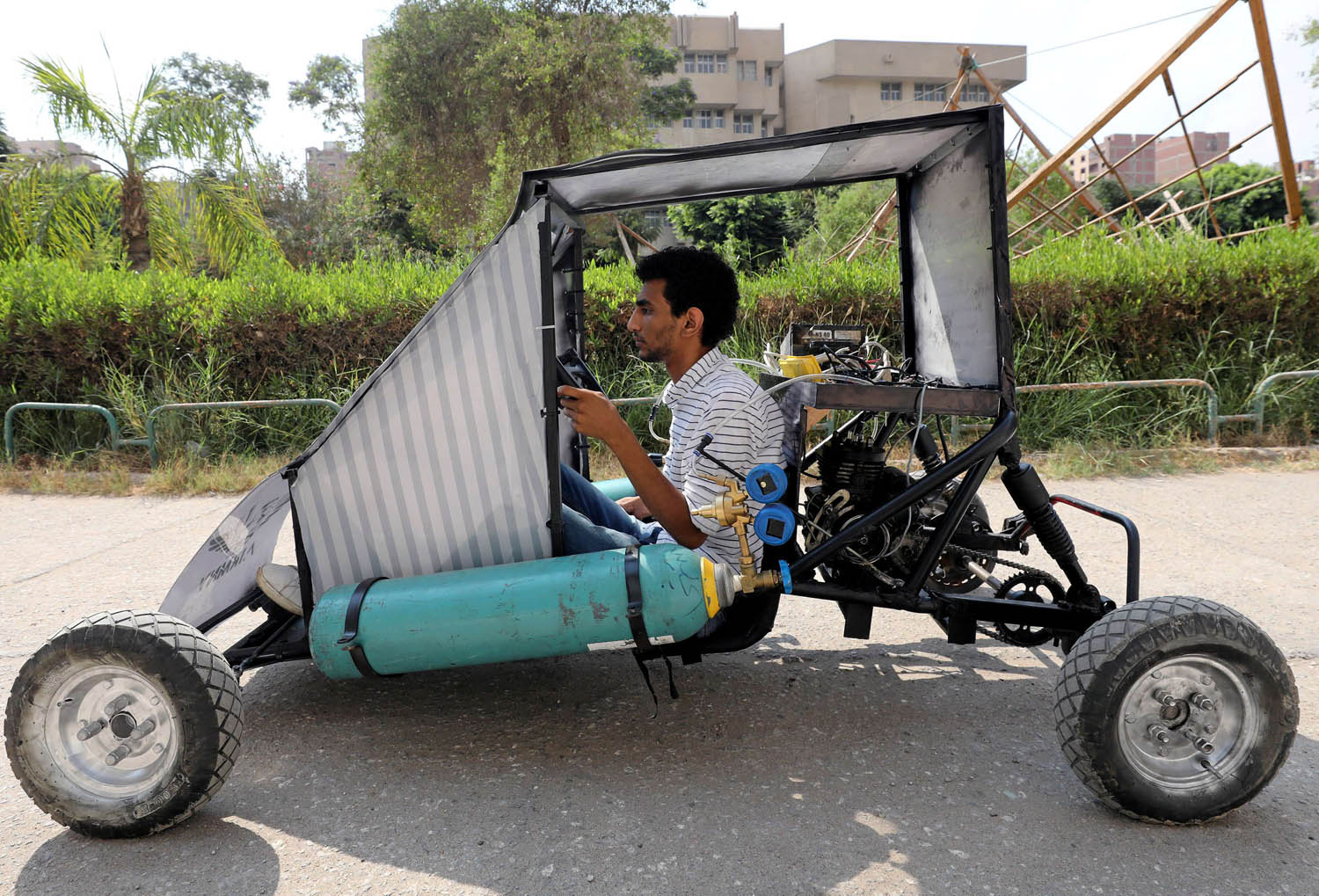 طالب من كلية الهندسة في جامعة حلوان يستعرض سيارة تعمل بالغاز قام بتصميمها وتنفيذها