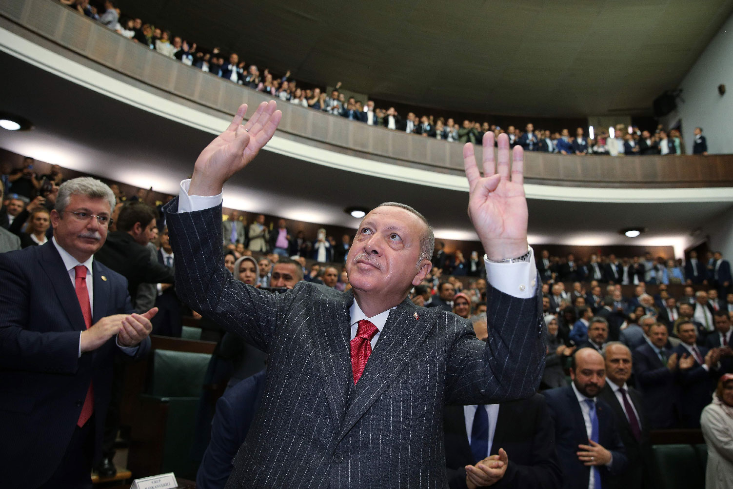 Turkish President Recep Tayyip Erdogan (C) gesturing in front of members of ruling Justice and Development Party (AKP)