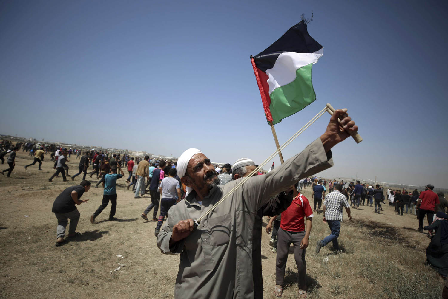 فلسطيني يرمي بحجارة على الحدود بين غزة وإسرائيل