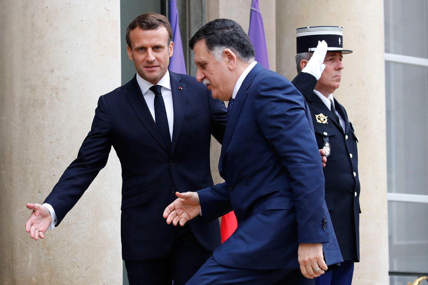 French President Emmanuel Macron (R) welcomes Libyan Prime Minister Fayez Sarraj