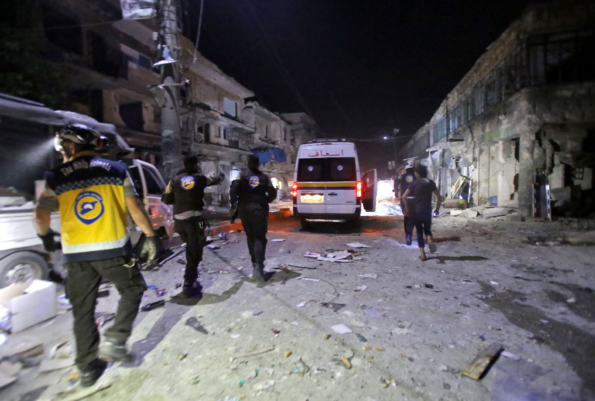 White Helmets rescue volunteers gather at the site of an air strike on a market in the town of Maarat al-Numan