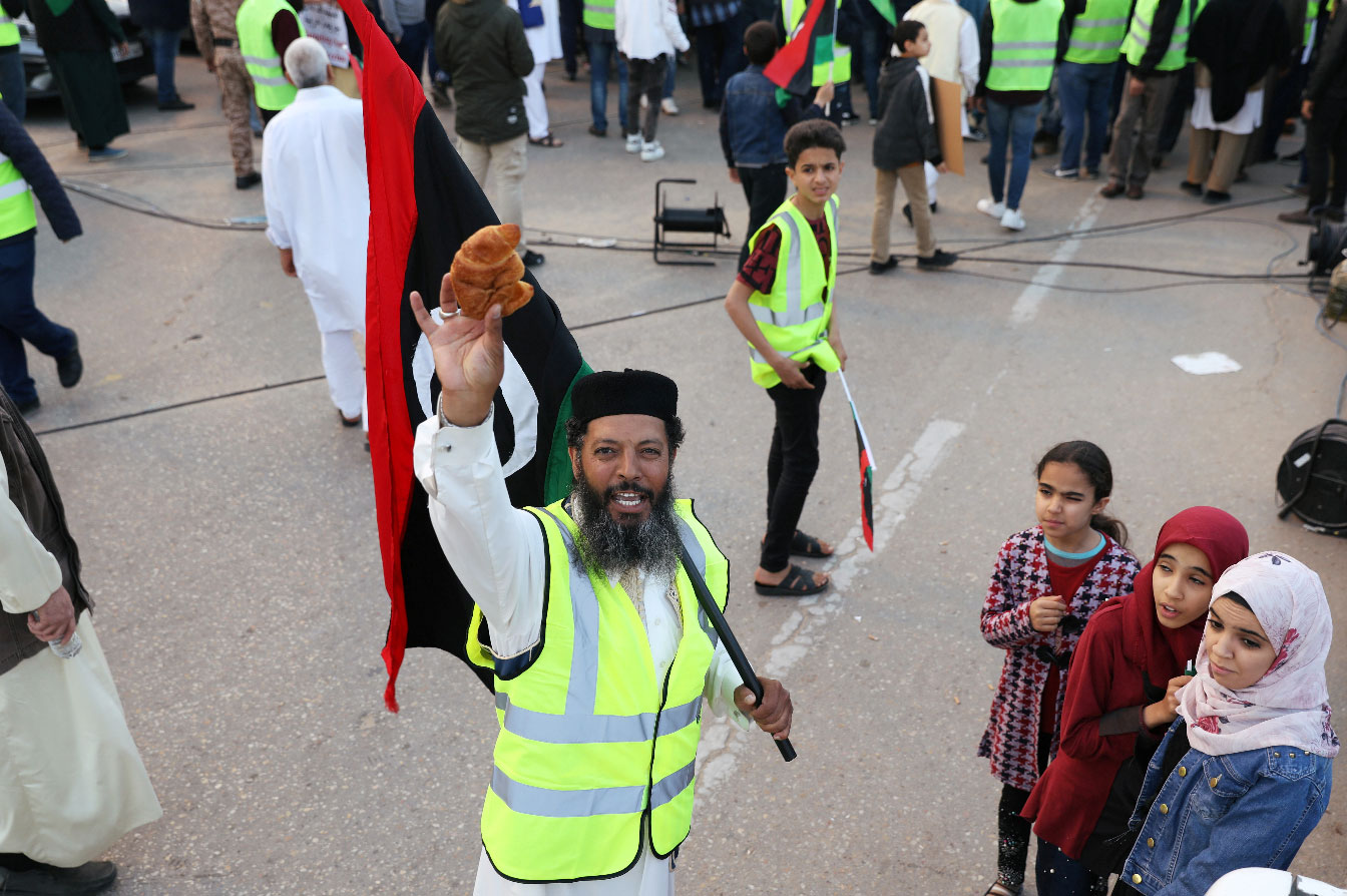 A Libyan protester holds a croissant as he attends a demonstration in Tripoli