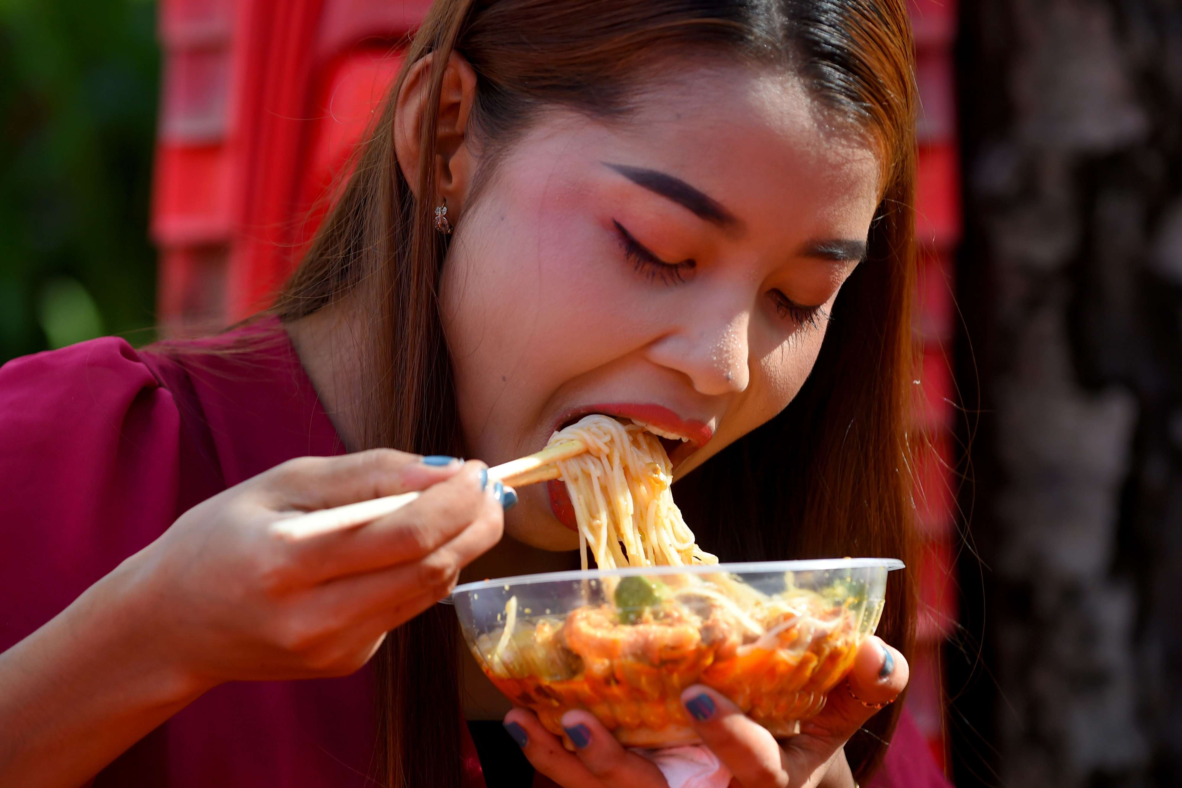 فتاة تأكل المعكرونة في أحد مطاعم كمبوديا