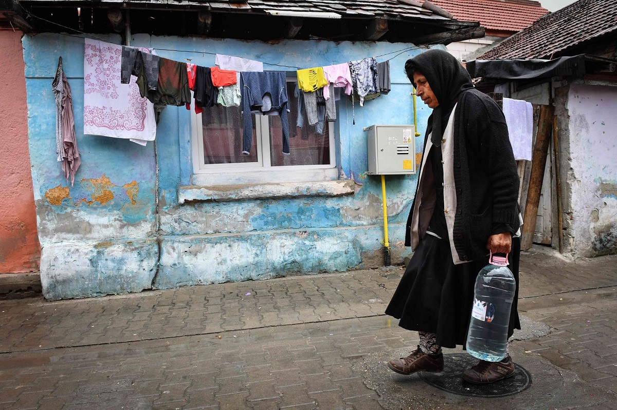 امرأة تحمل مياها للشرب داخل حي فقير لغجر الروما