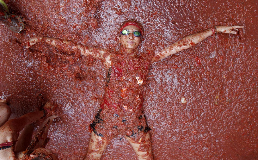 شاب يغطس في عصير الطماطم في مهرجان الطماطم في إسبانيا