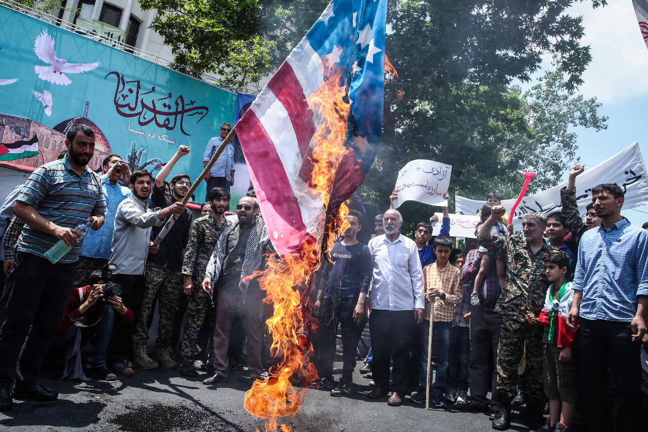 An Iranian man burns the US flag during a protest in Tehran