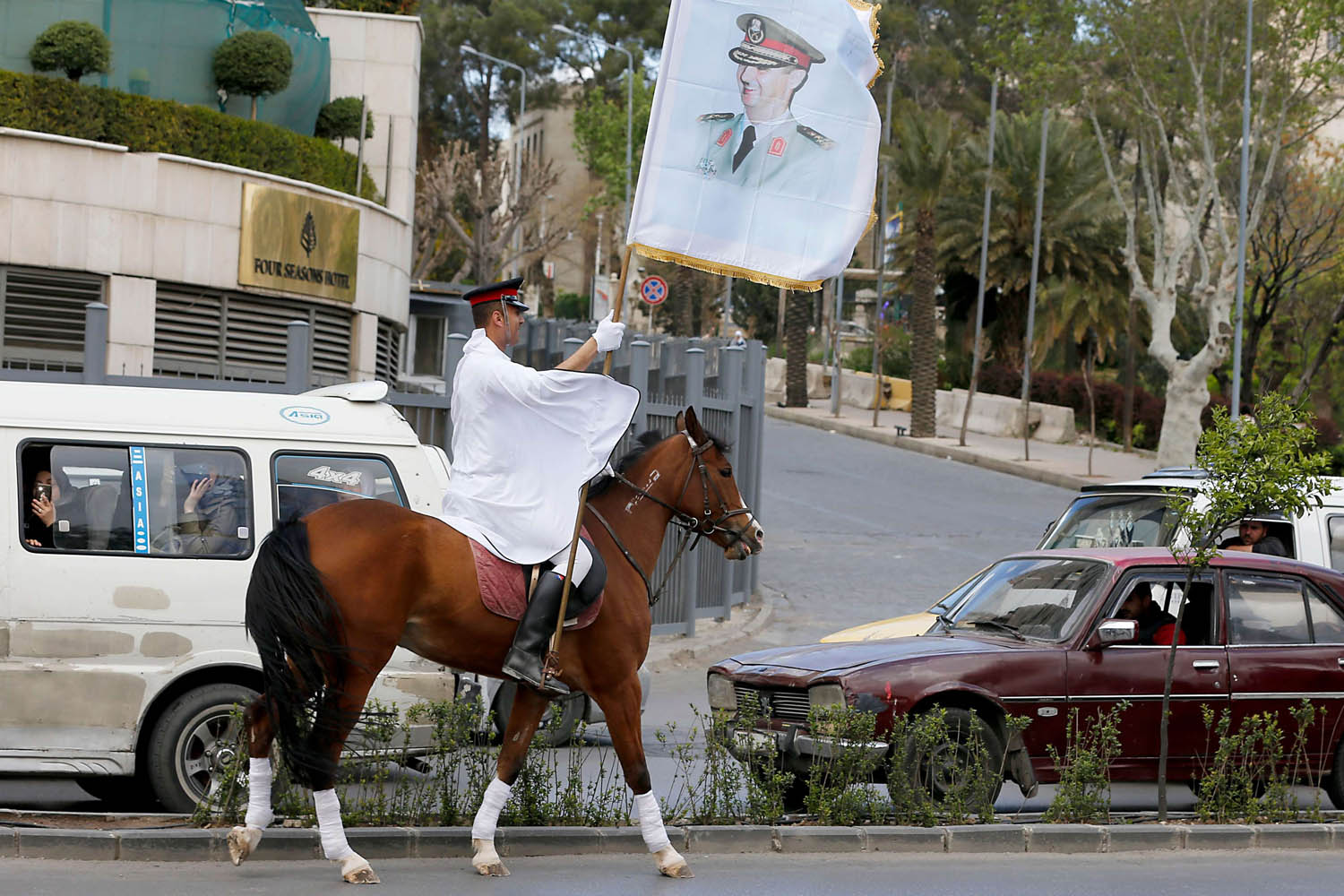 جندي سوري يرفع راية تحمل صورة الرئيس بشار الأسد وسط دمشق
