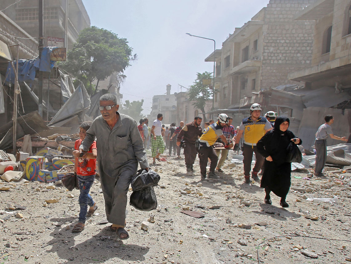 Syrians flee following an air strike on the town of Maaret al-Numan in Idlib province