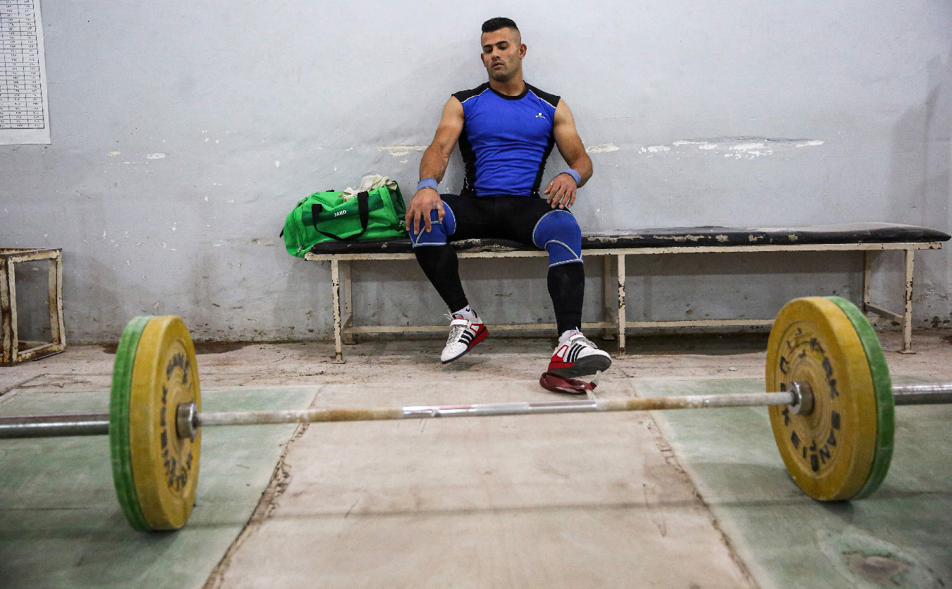 Iraqi weightlifter Safaa Rashed Aljumaili sits on a bench during training at a gym in the capital Baghdad