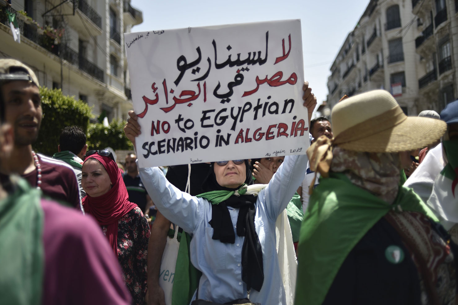 An Algerian woman raises a placard as she takes part in a weekly demonstration in the capital Algiers