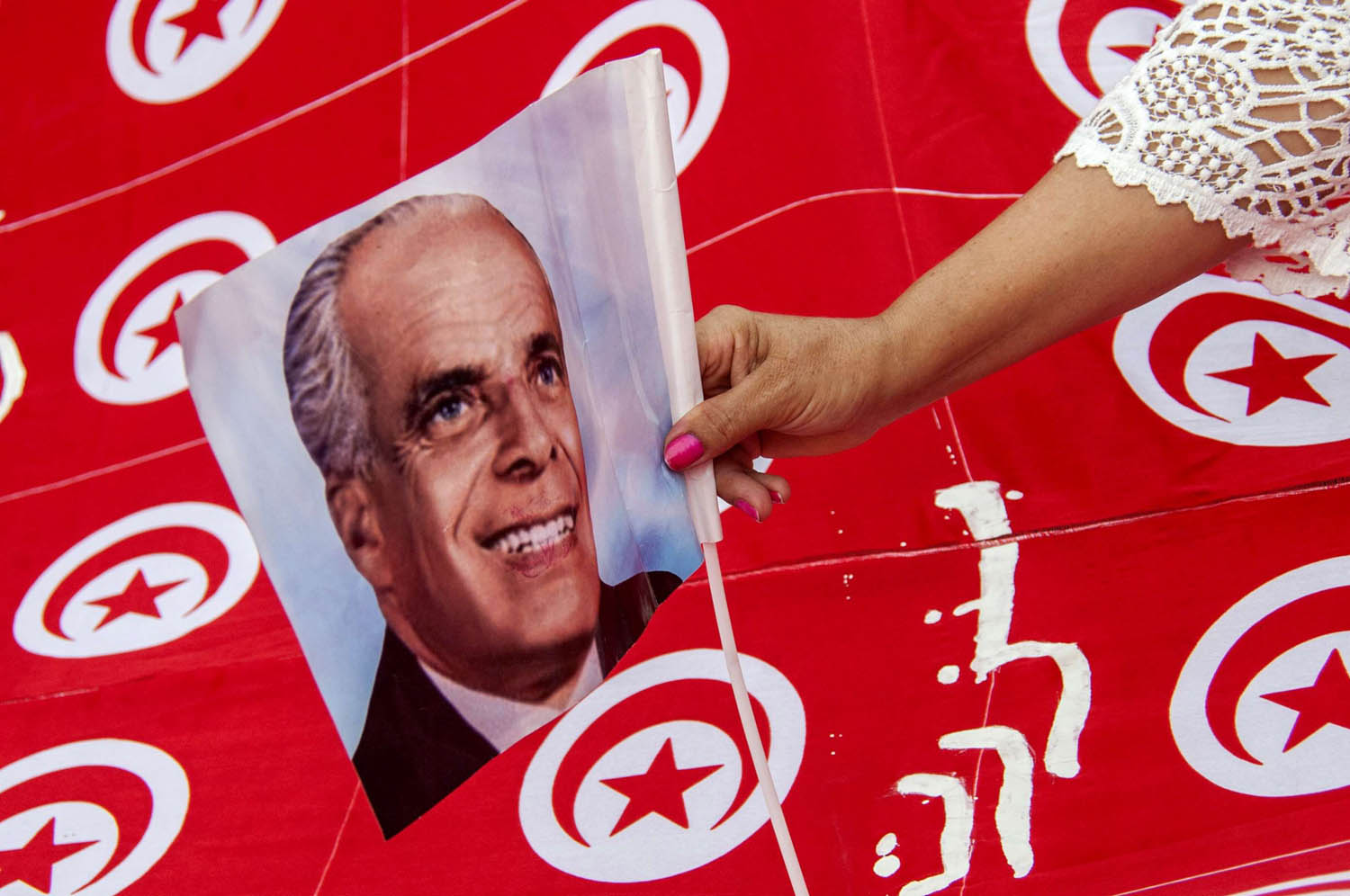 تونسية ترفع صورة الرئيس الراحل الحبيب بورقيبة