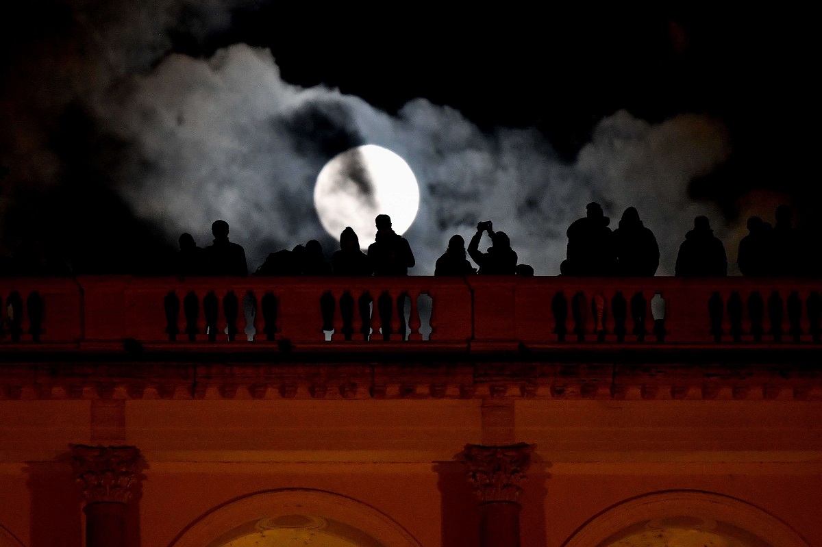 أشخاص يراقبون القمر العملاق في مدينة روما بايطاليا